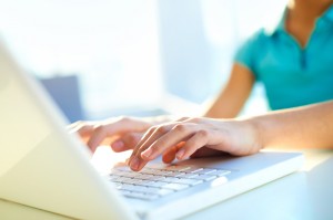 Close-up shot of a female typing on a laptop keyboard